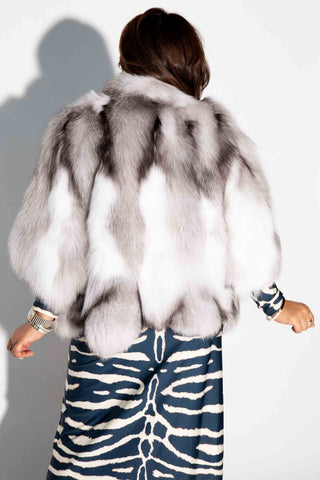 back of woman wearing a shadow black frost sectioned mink fur capelet against a white backdrop