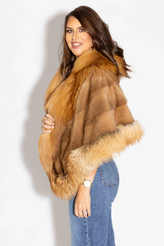 side profile of woman wearing whisky mink fur cape with natural red fox fur trim against a white backdrop