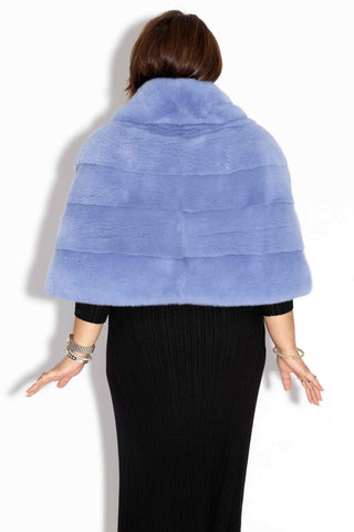 back of woman wearing a baby blue mink fur stole with shawl collar, against a white backdrop