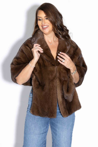 smiling woman wearing a demi buff mink fur stole with shawl collar against a white backdrop