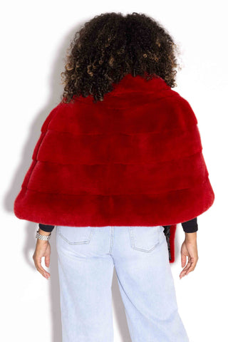 back of woman wearing a red mink fur stole with shawl collar against a white backdrop