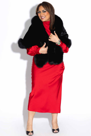 woman wearing a ranch chevron sectioned mink fur cape with fox fur trim against a white backdrop