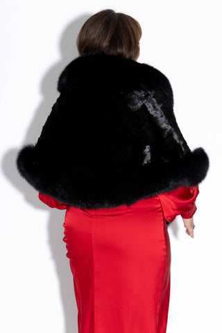 back of woman wearing a ranch chevron sectioned mink fur cape with fox fur trim against a white backdrop