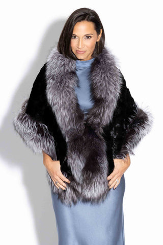 woman wearing a ranch chevron sectioned mink fur cape with silver fox fur trim against a white backdrop