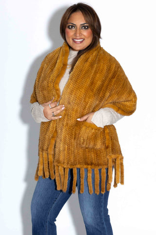 smiling woman wearing a whisky knitted mink fur shawl against a white backdrop