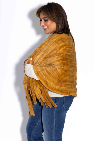 side profile smiling woman wearing a whisky knitted mink fur shawl against a white backdrop