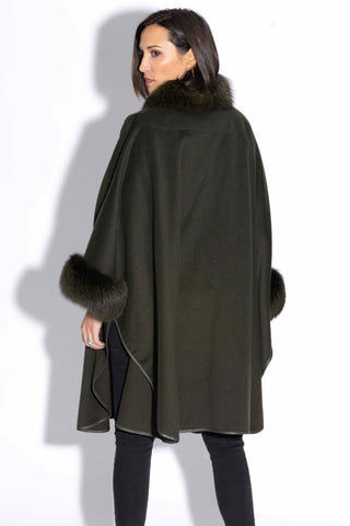 back of woman wearing an olive cashmere & wool blend cape with fox fur trim against a white backdrop