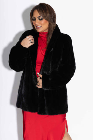 woman wearing a ranch mink fur jacket against a white backdrop