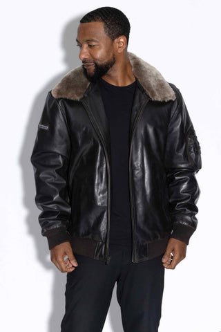smiling man wearing a leather bomber with wool collar against a white backdrop