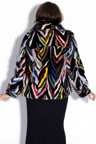 back of woman wearing a multicolor sectioned mink fur bolero jacket against a white backdrop