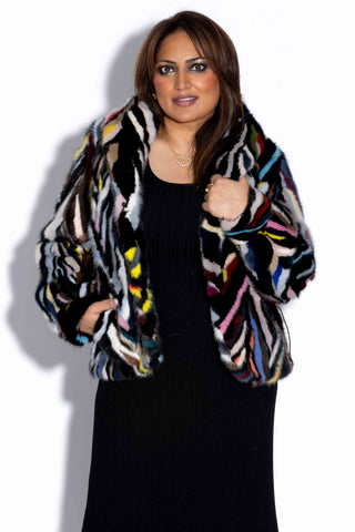 woman wearing a multicolor sectioned mink fur bolero jacket against a white backdrop