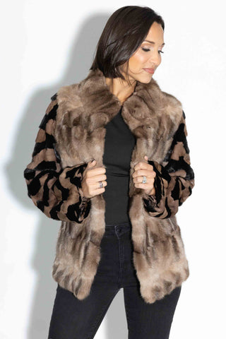 woman wearing a sectioned mink fur jacket with sable fur front against a white backdrop