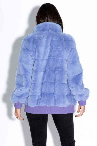 back of woman wearing a lilac nafa mink fur jacket against a white backdrop