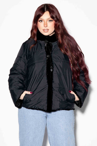 woman wearing a reversible sectioned mink fur jacket with the down puffy jacket on the outside against a white backdrop