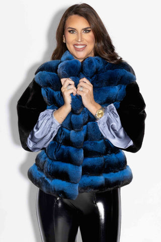 smiling woman wearing a blue chinchilla fur bolero jacket with ranch mink fur back against a white backdrop