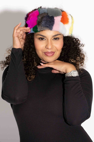 woman wearing a multicolor mink fur headband against a white backdrop