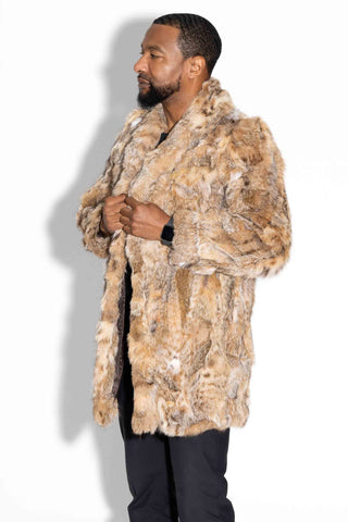 profile of a man wearing a sectioned bobcat fur stroller against a white backdrop