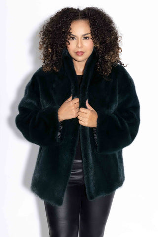 woman wearing evergreen full skin mink fur jacket against a white backdrop