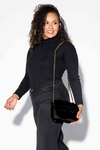 woman wearing a ranch mink fur purse against a white backdrop