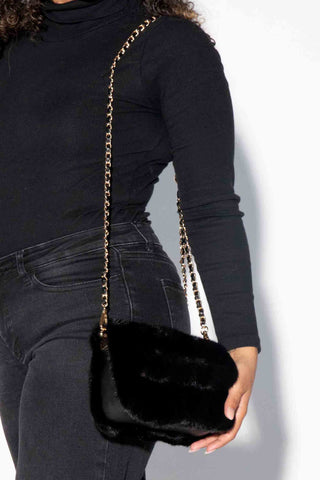 closer view of woman wearing a ranch mink fur purse against a white backdrop