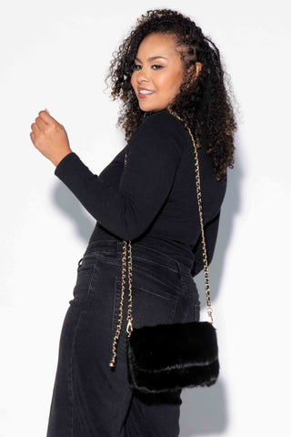 woman wearing a ranch mink fur purse against a white backdrop
