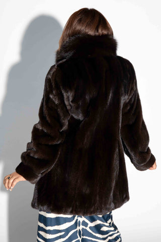 back of woman wearing a mahogany mink fur stroller with fox fur tux against a white backdrop