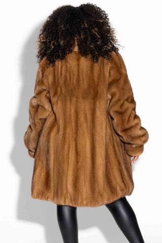 back of woman wearing a whisky mink fur stroller with shawl collar against a white backdrop