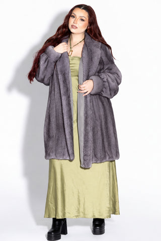 woman wearing a blue iris mink fur stroller with shawl collar against a white backdrop