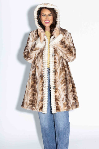 smiling woman wearing a beige cross reversible sheared sectioned mink fur stroller with hood against a white backdrop, with the hood on her head