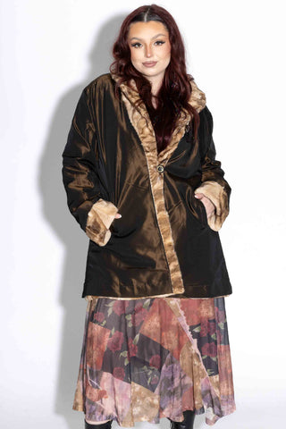 woman wearing a beige cross reversible sheared sectioned mink fur stroller against a white backdrop