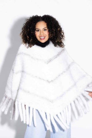 smiling woman wearing a black cross knitted mink fur poncho against a white backdrop