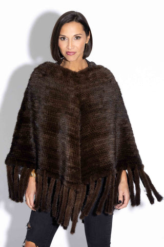 woman wearing a brown knitted mink fur poncho against a white backdrop