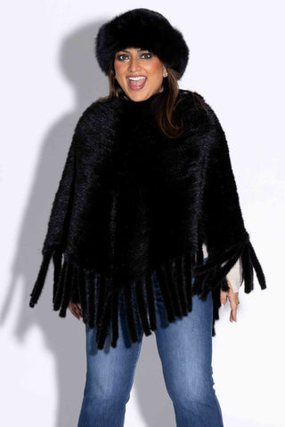 smiling lady wearing a ranch knitted mink fur poncho against a white backdrop
