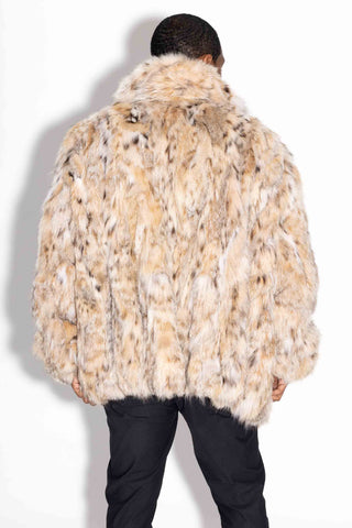 back of man wearing a sectioned bobcat fur bomber jacket against a white backdrop