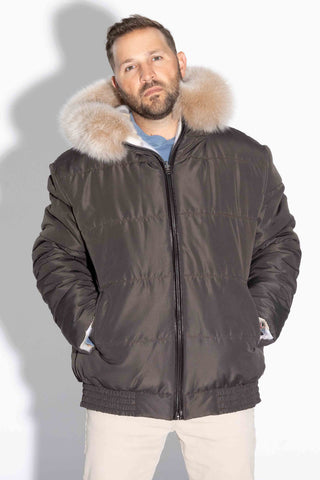 man wearing a reversible natural multicolor sectioned mink fur jacket with brown fox fur trimmed hood, with brown cloth side facing out, against a white backdrop