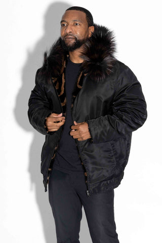 man wearing a reversible ranch and brown sectioned mink fur jacket with the black cloth side facing out, against a white backdrop