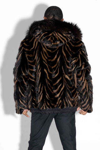 back of man wearing a ranch and brown reversible mink fur jacket with brown fox fur trimmed hood against a white backdrop