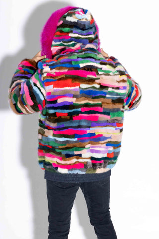 back of man wearing a pink multicolor sectioned mink fur bomber jacket with pink fox fur trimmed hood up