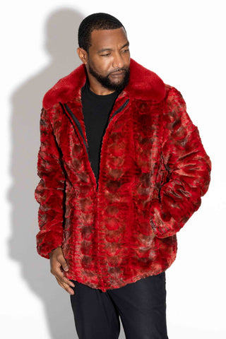 man wearing a red sheared sectioned mink fur bomber jacket with mink fur collar against a white backdrop, with his hand in the pocket
