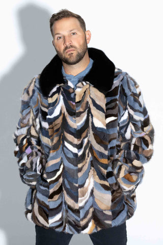 man wearing a multicolor sectioned mink fur bomber jacket with ranch mink fur collar against a white backdrop