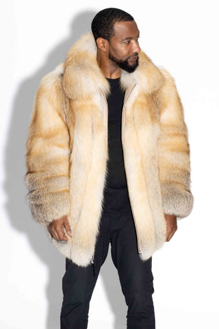 man wearing a custom-made full skin golden island fox fur bomber jacket against a white backdrop