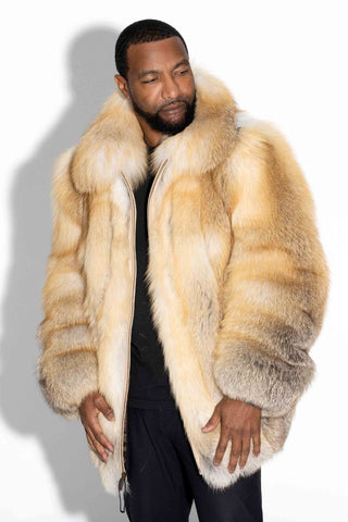 man wearing a custom-made full skin golden island fox fur bomber jacket against a white backdrop