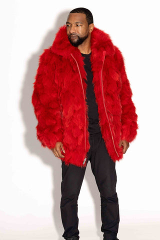 man wearing a red sectioned fox fur bomber jacket against a white backdrop