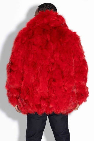 back of man wearing a red sectioned fox fur bomber jacket against a white backdrop