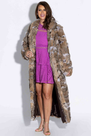 woman wearing a sectioned bobcat fur coat against a white backdrop