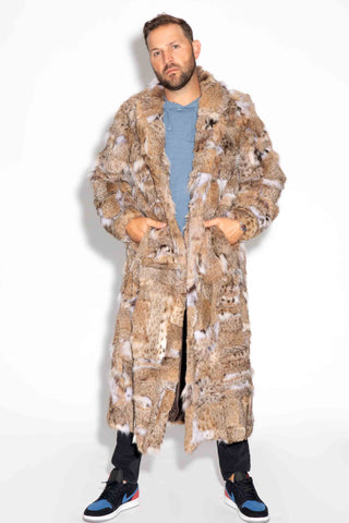 man wearing a sectioned bobcat fur coat with shawl collar against a white backdrop