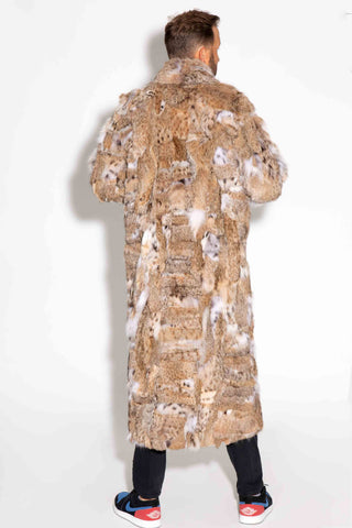 back of man wearing a sectioned bobcat fur coat with shawl collar against a white backdrop