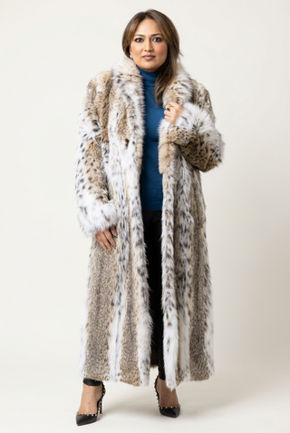 woman wearing a full-length bobcat fur coat on a white backdrop