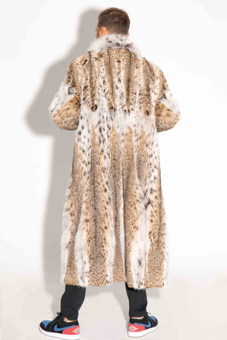 back of man wearing a bobcat fur coat with a shawl collar against a white backdrop