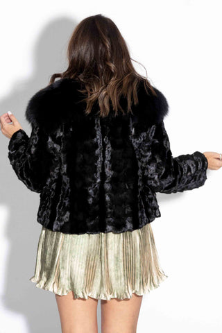 back of woman wearing a ranch sheared sectioned mink fur jacket with black fox fur tux against a white backdrop